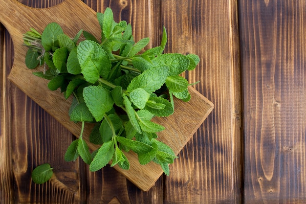 Mazzo di menta fresca nel tagliere sul legno marrone