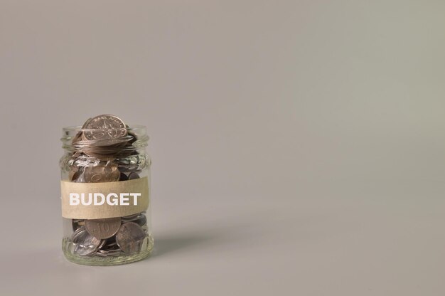 Mazzo di monete in un barattolo di vetro con testo BUDGET