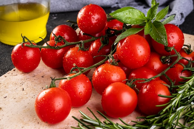 Mazzo di pomodori con foglie di basilico e rami di rosmarino.