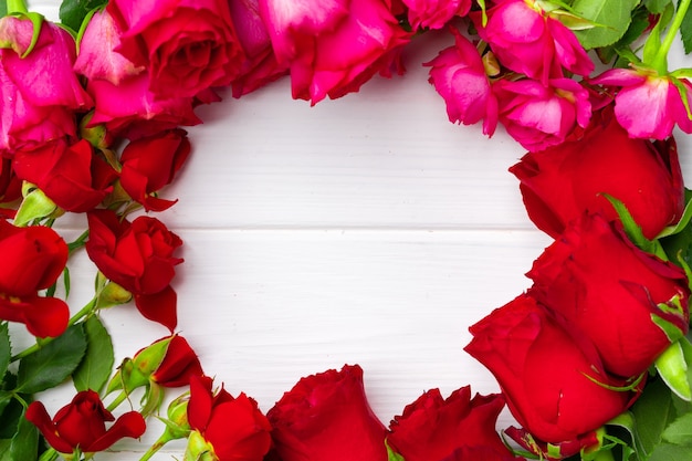 Mazzo di rose rosse e rosa sulla vista superiore del fondo di legno bianco