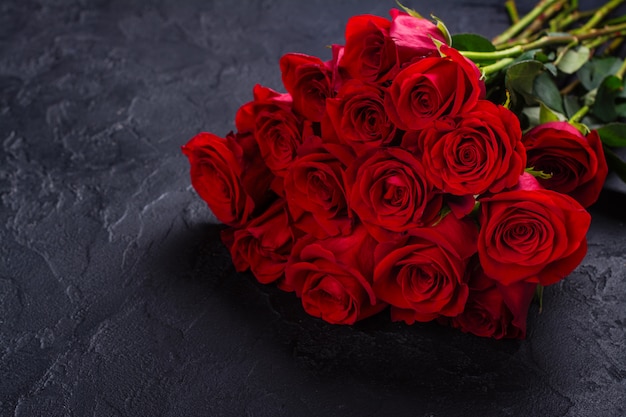 Mazzo di rose rosse su pietra nera