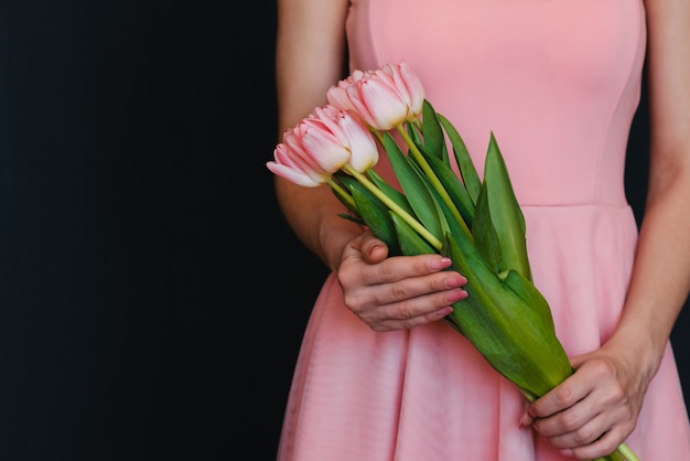 Mazzo di tulipani rosa in mani della donna