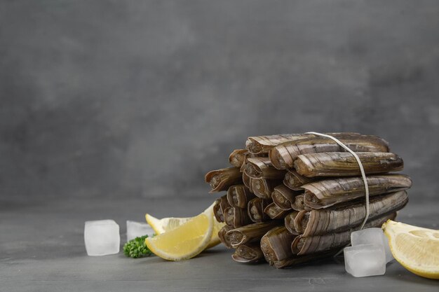 Mazzo di vongole rasoio sullo sfondo pietra grigia Primo piano di pesce fresco