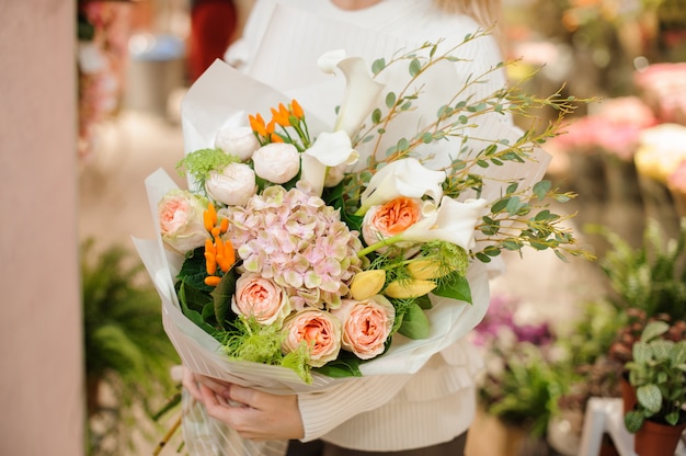 Mazzo multicolore stupefacente del biglietto di S. Valentino dei fiori in mani femminili