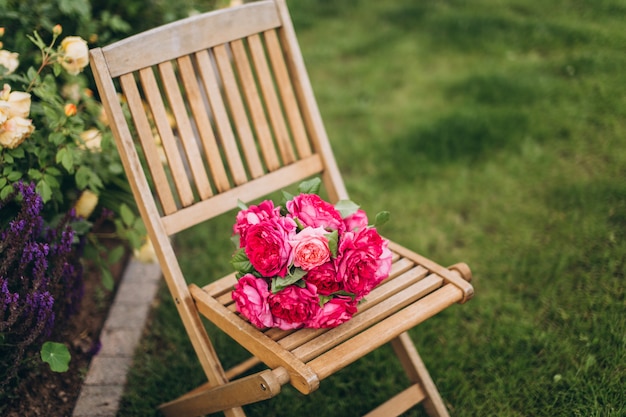 Mazzo rosa delle rose sulla sedia di legno