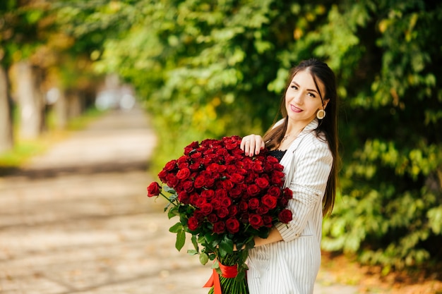 Mazzo sentente l'odore di giovane bellezza delle rose rosse. Piacere e armonia