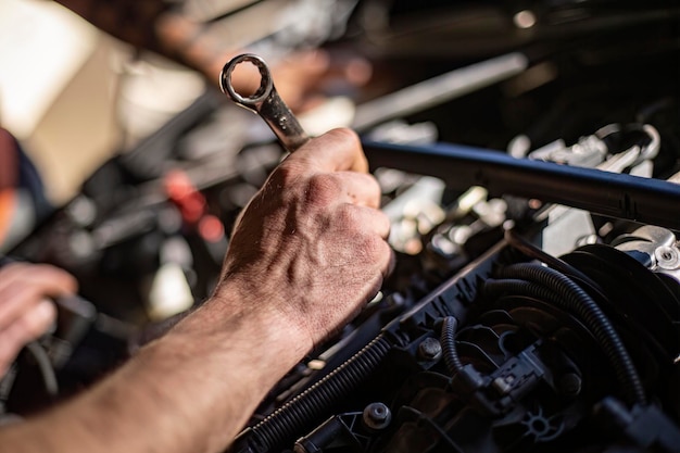 Meccanici mani sporche che riparano il motore dell'auto