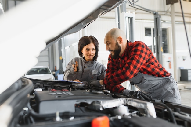 Meccanici maschi e femmine che lavorano su auto