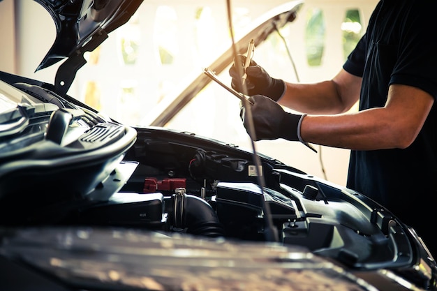 Meccanico automatico a mano in primo piano che utilizza la chiave per riparare il problema del motore dell'auto Concetti di controllo e ispezione, manutenzione e assistenza per la cura dell'auto