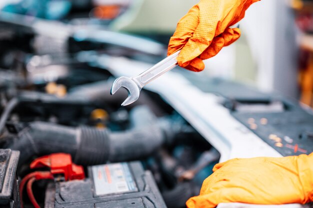 Meccanico automatico che lavora in garage Servizio di riparazione del motore