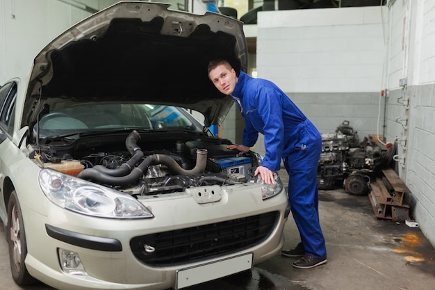 Meccanico che esamina il motore dell&#39;auto