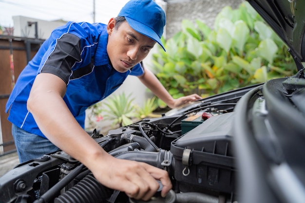 Meccanico che fa qualche ispezione sul motore dell'automobile