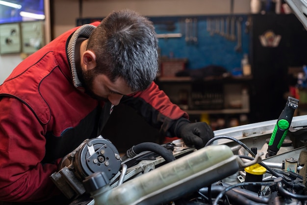 Meccanico che lavora al motore in officina