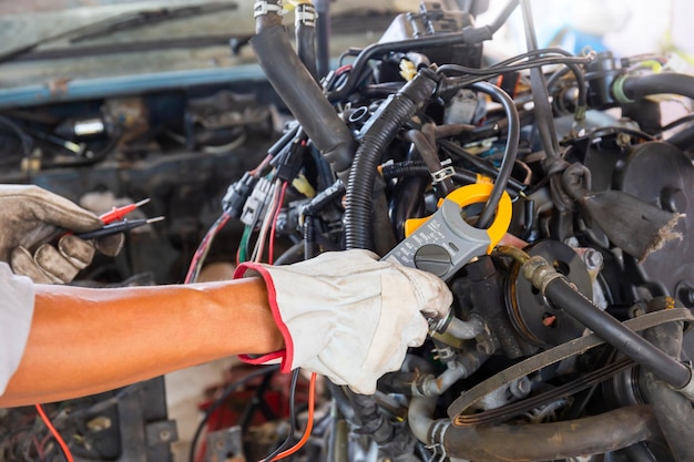 Meccanico che lavora sul motore dell'auto nel garage dei meccanici Servizio di riparazione e manutenzione Manutenzione e concetti di riparazione