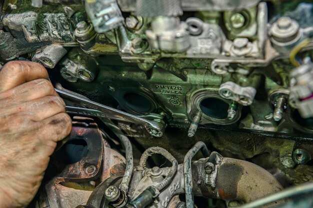 Meccanico che ripara il motore di un'auto in officina