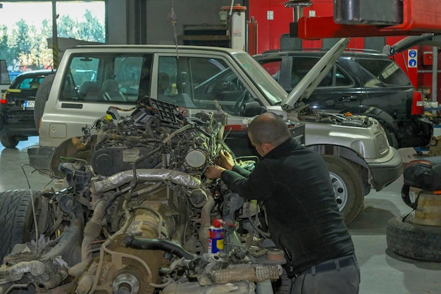 Meccanico che ripara il motore di un'auto in officina