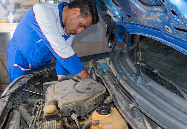 Meccanico che ripara l'auto in un negozio di riparazione automobilistica