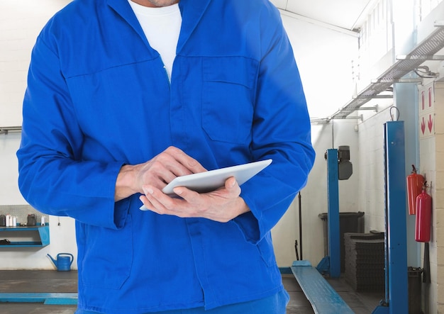 Meccanico che utilizza la tavoletta digitale in officina