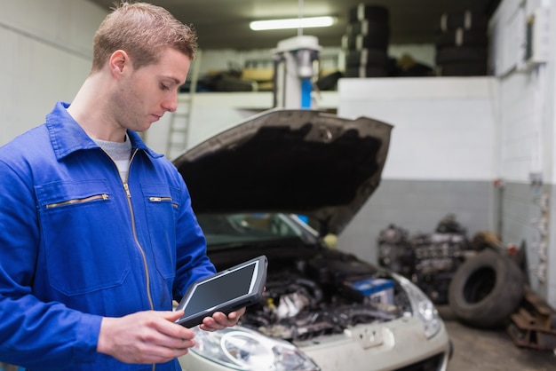 Meccanico con tavoletta digitale al garage