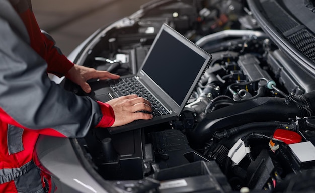 Meccanico delle colture che conduce la diagnostica dell'auto in officina