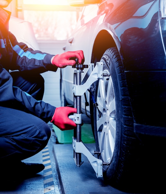 Meccanico di automobile che installa sensore durante la regolazione delle sospensioni.