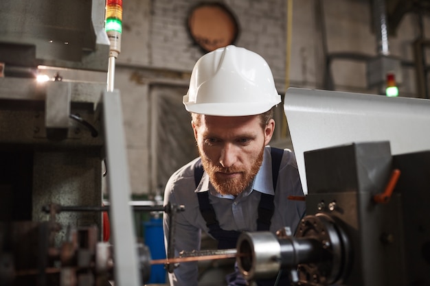 Meccanico guardando il lavoro della macchina