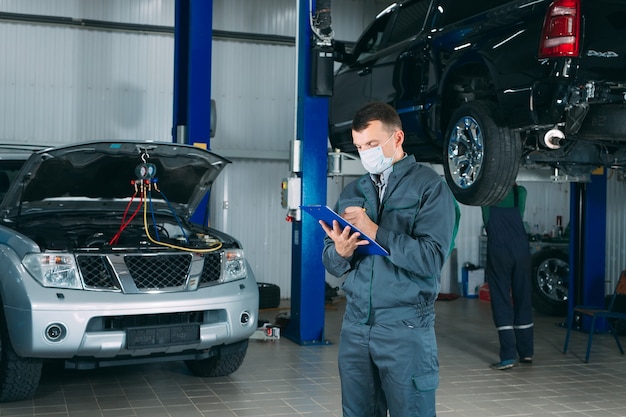 Meccanico mantenendo il record di auto negli appunti presso l'officina.