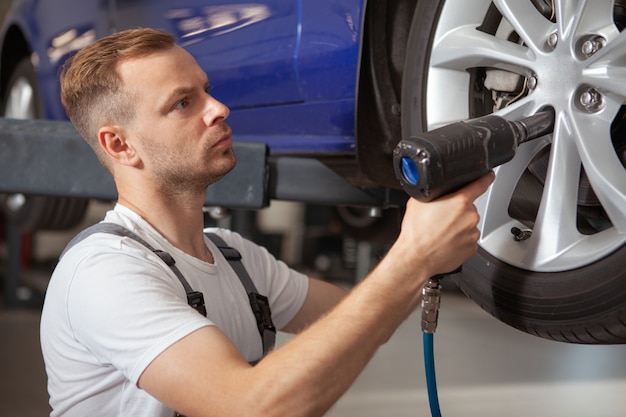 Meccanico maschio maturo che lavora al garage