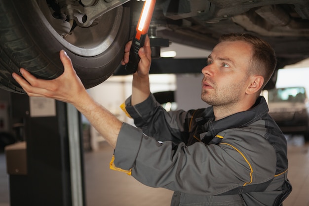 Meccanico maschio maturo che lavora al garage