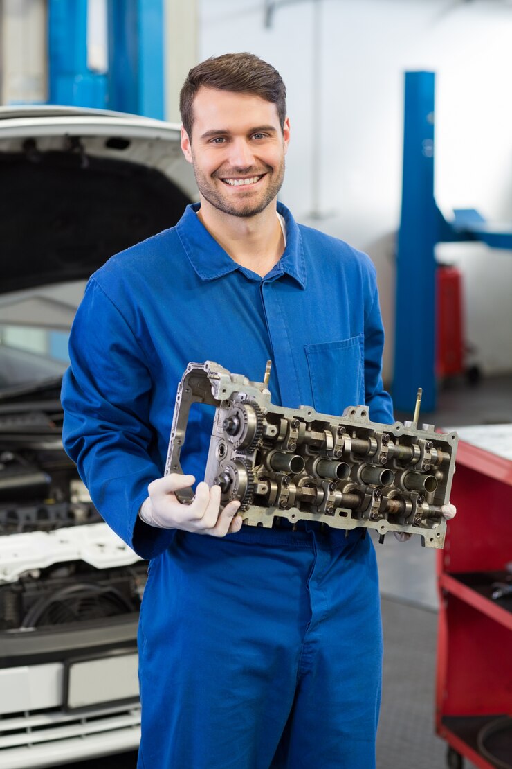 Foto meccanico sorridente che tiene un motore