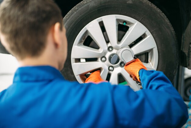 Meccanico svita ruota auto, servizio gomme.