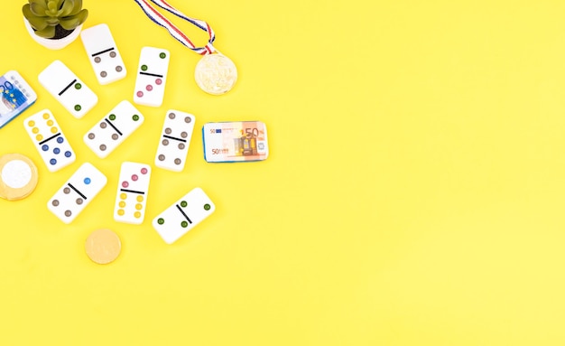 Medaglia del domino bianco e denaro di cioccolato su sfondo giallo Vista dall'alto Gioco da tavolo Posto per il testo