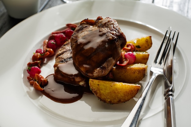 Medaglioni di maiale alla griglia con funghi in salamoia e patate arrosto.