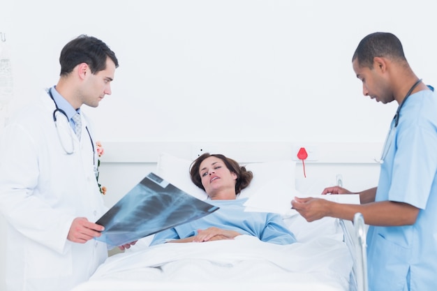 Medici che esaminano i raggi x dal paziente in ospedale