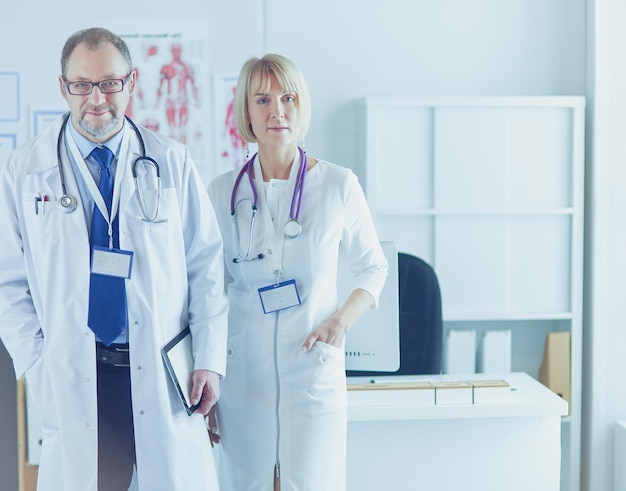 Medici che sorridono alla telecamera in studio medico