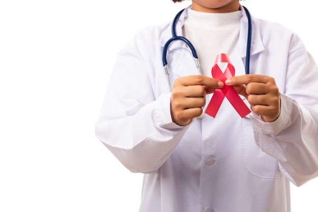 Medici della donna in uniforme che tiene il nastro rosso di consapevolezza di HIV AIDS di sostegno sulle mani