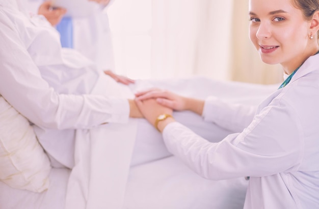 Medici e infermieri che impilano le mani isolate su bianco