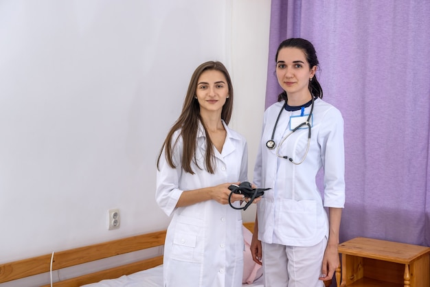 Medici sorridenti giovani e fiduciosi in posa in ospedale