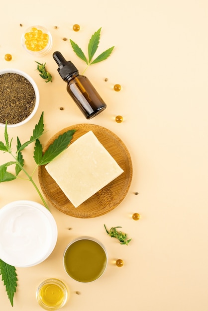 Medicina alternativa, cosmetici naturali. olio di CBD e foglie di cannabis cosmetici vista dall'alto su sfondo arancione, piatto disteso