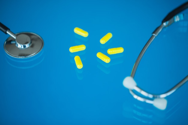 Medicine, integratori e droghe in una bottiglia sul blu
