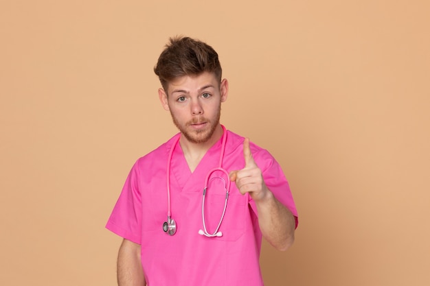 Medico africano che indossa un'uniforme rosa su un fondo giallo
