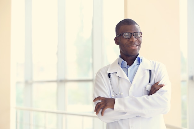 Medico afroamericano bello con lo stetoscopio in ospedale