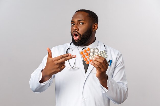 Medico afroamericano del ritratto in uniforme bianca.