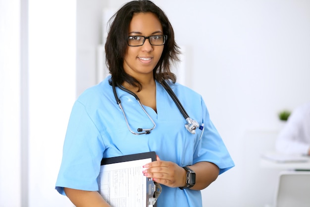 Medico afroamericano femminile con i colleghi in background