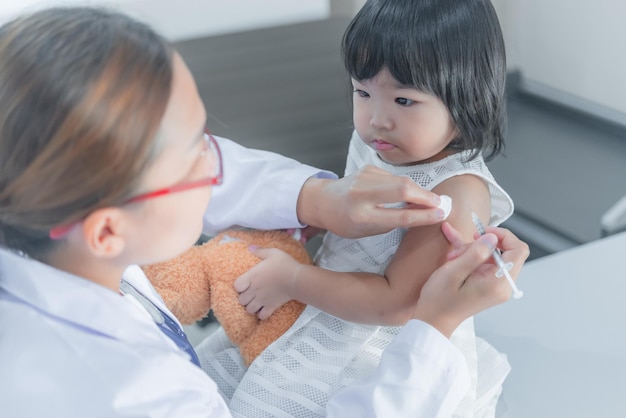 Medico asiatico Preparando per l'iniezione con una siringa una bella ragazza controlla la salute dei bambiniLa gente della Thailandia