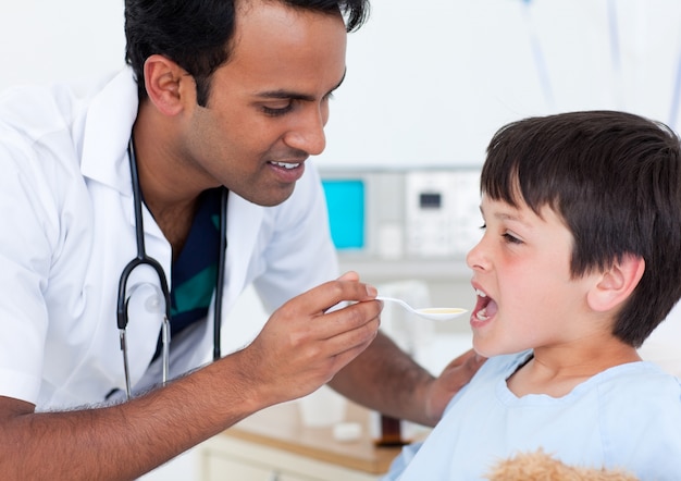 Medico attraente che dà medicina ad un ragazzino
