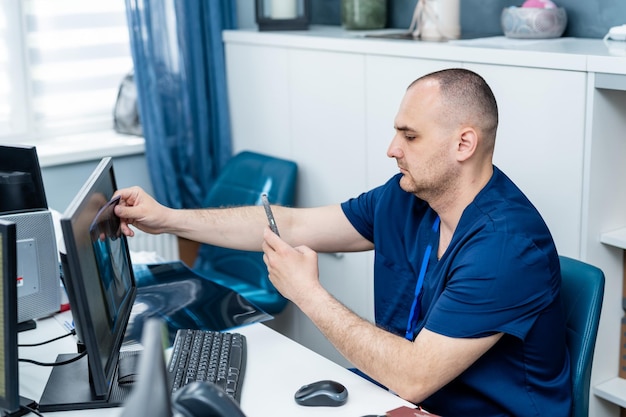 Medico bello che lavora con il computer in ospedale Clinica professionale maschio con il computer