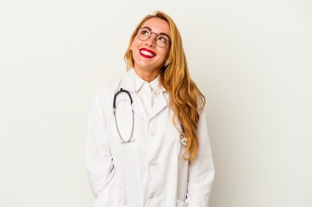 Medico caucasico donna isolata su sfondo bianco che sogna di raggiungere obiettivi e scopi