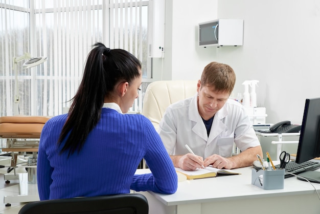 Medico che consulta giovane donna nel suo ufficio