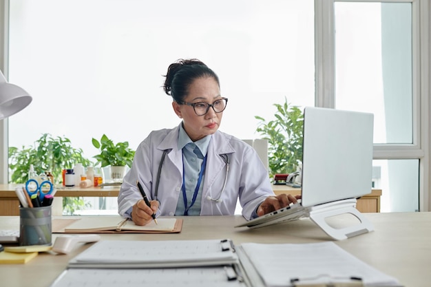 Medico che controlla i dati sul computer portatile